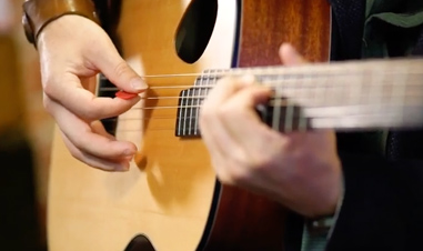 hands playing acoustic guitar