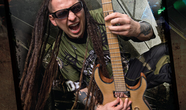 man with dreadlocks playing electric guitar